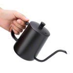 Swan neck kettle pouring water over coffee grounds in dripper