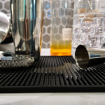 Rubber coffee bar mat 12x18 inch used on a café counter with coffee cups